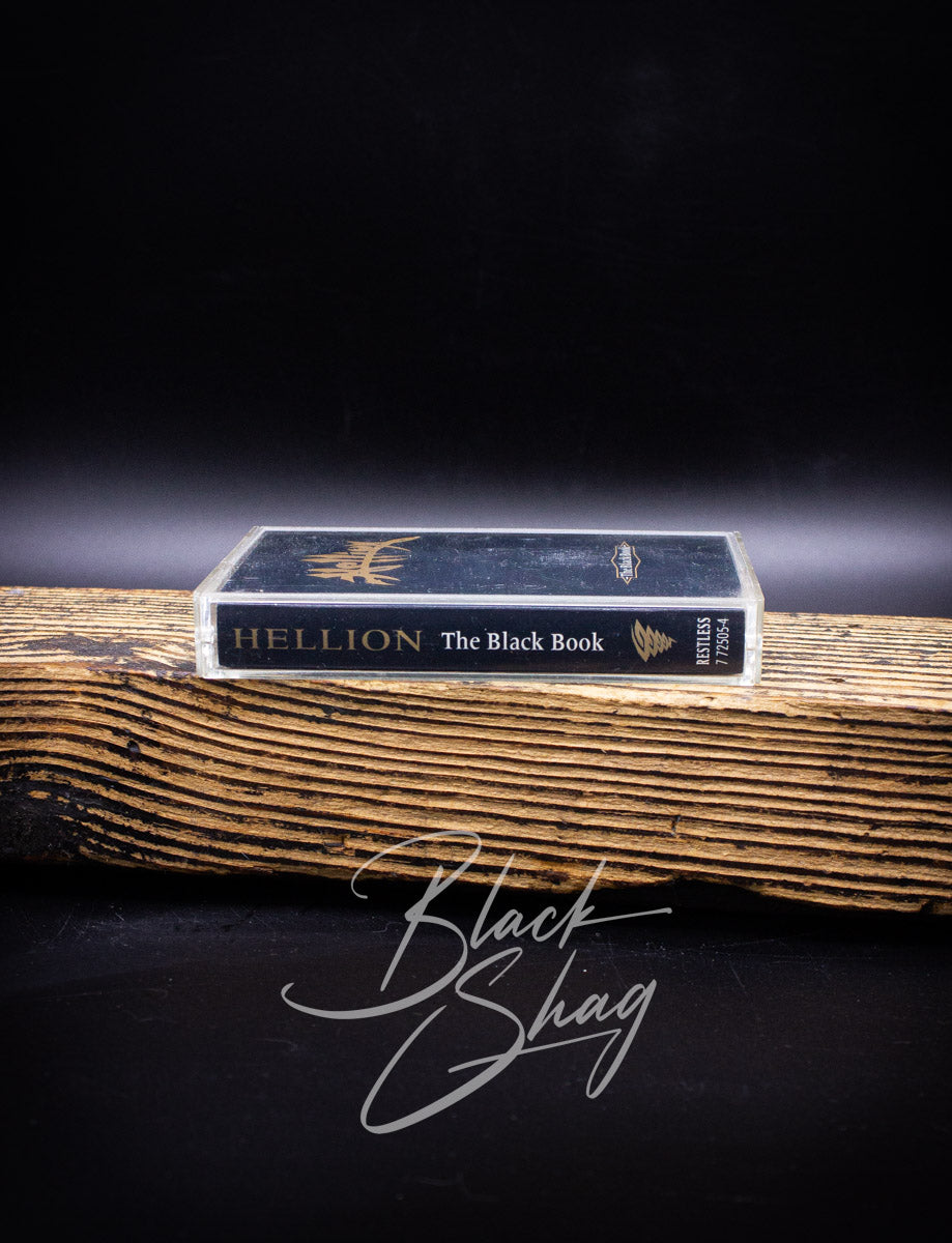 Book titled 'Hellion The Black Book' on a wooden surface with a dark background