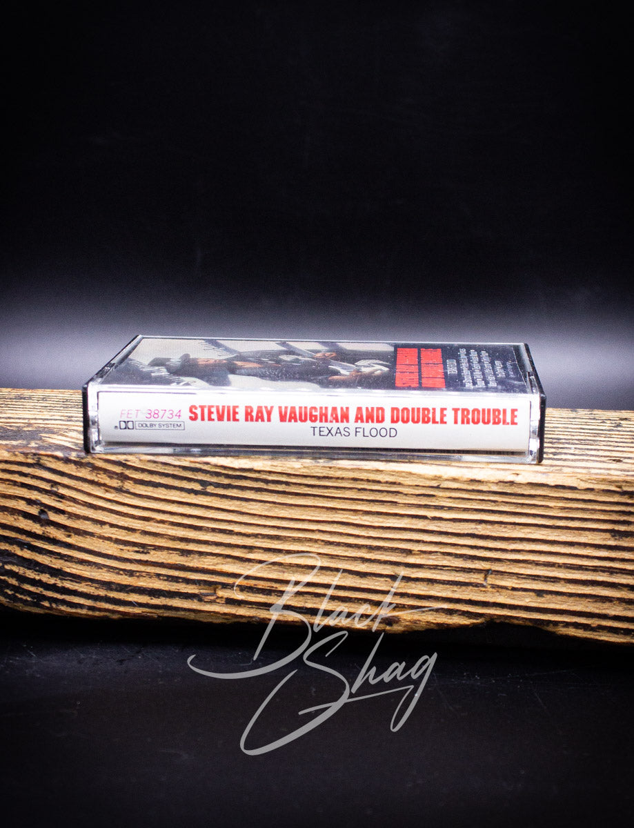 Stevie Ray Vaughan and Double Trouble 'Texas Flood' album on a wooden surface with a dark background